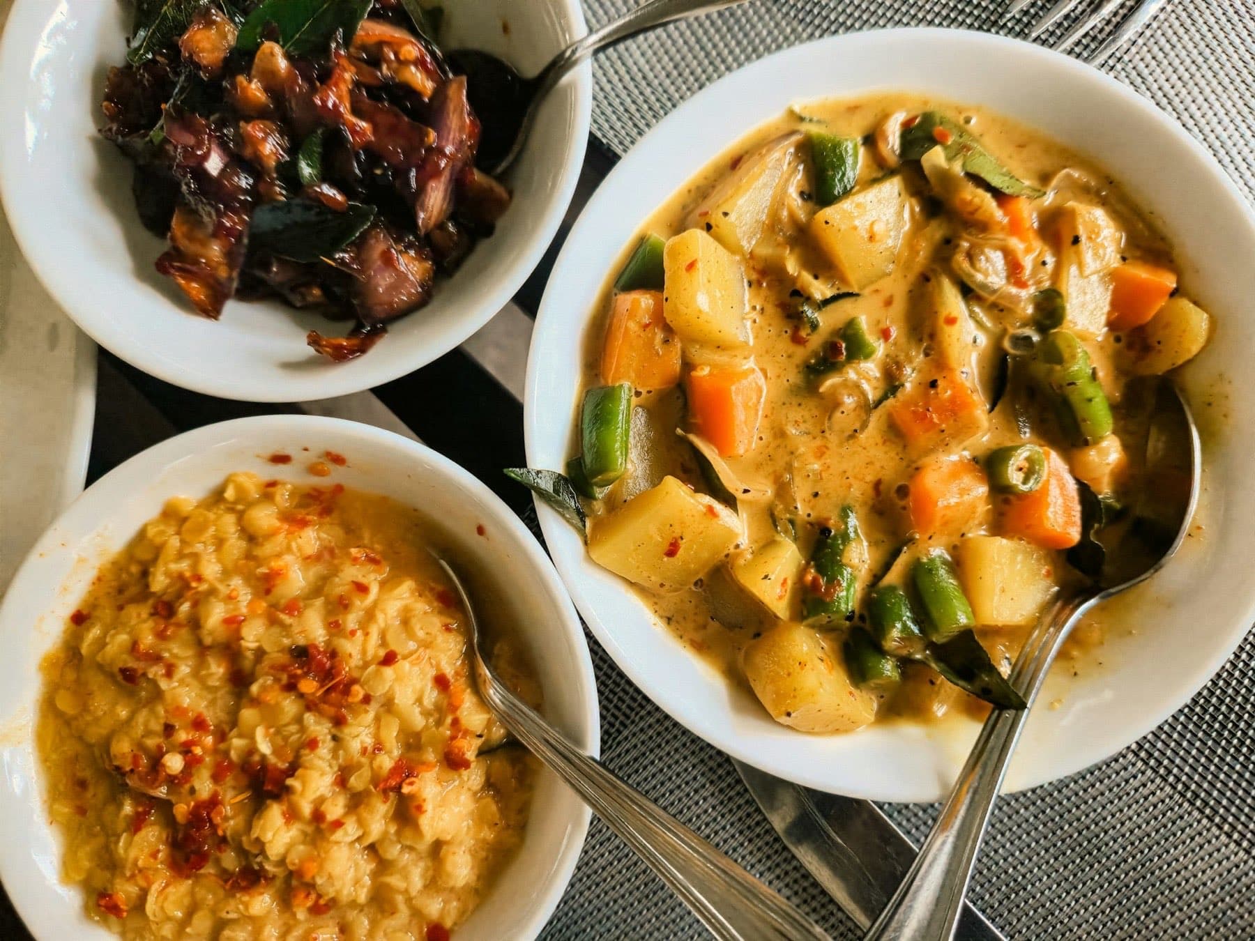 A traditional Sri Lankan rice and curry spread served with multiple vegetable curries and sambols