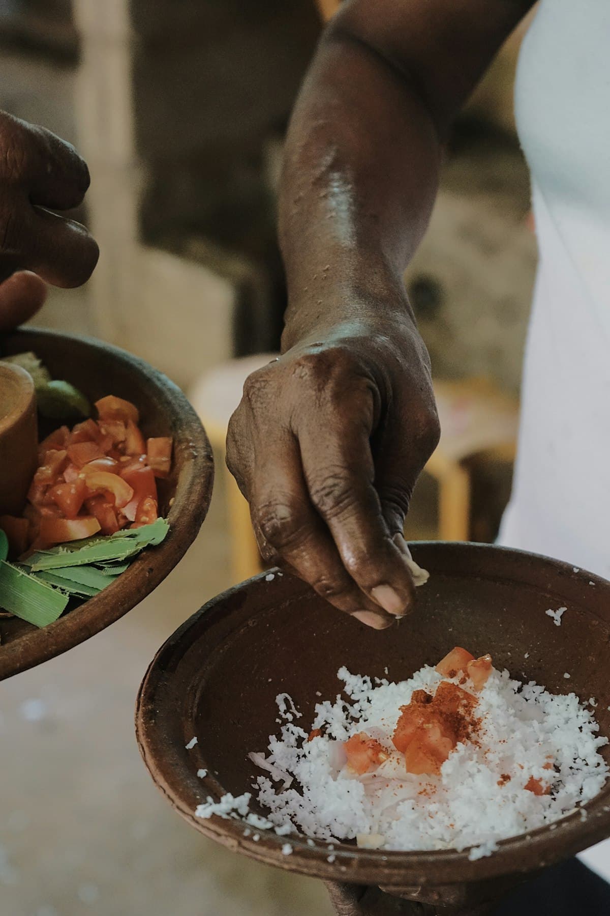 Hands adding spices in a traditional Sri Lankan kitchen during a family cooking session