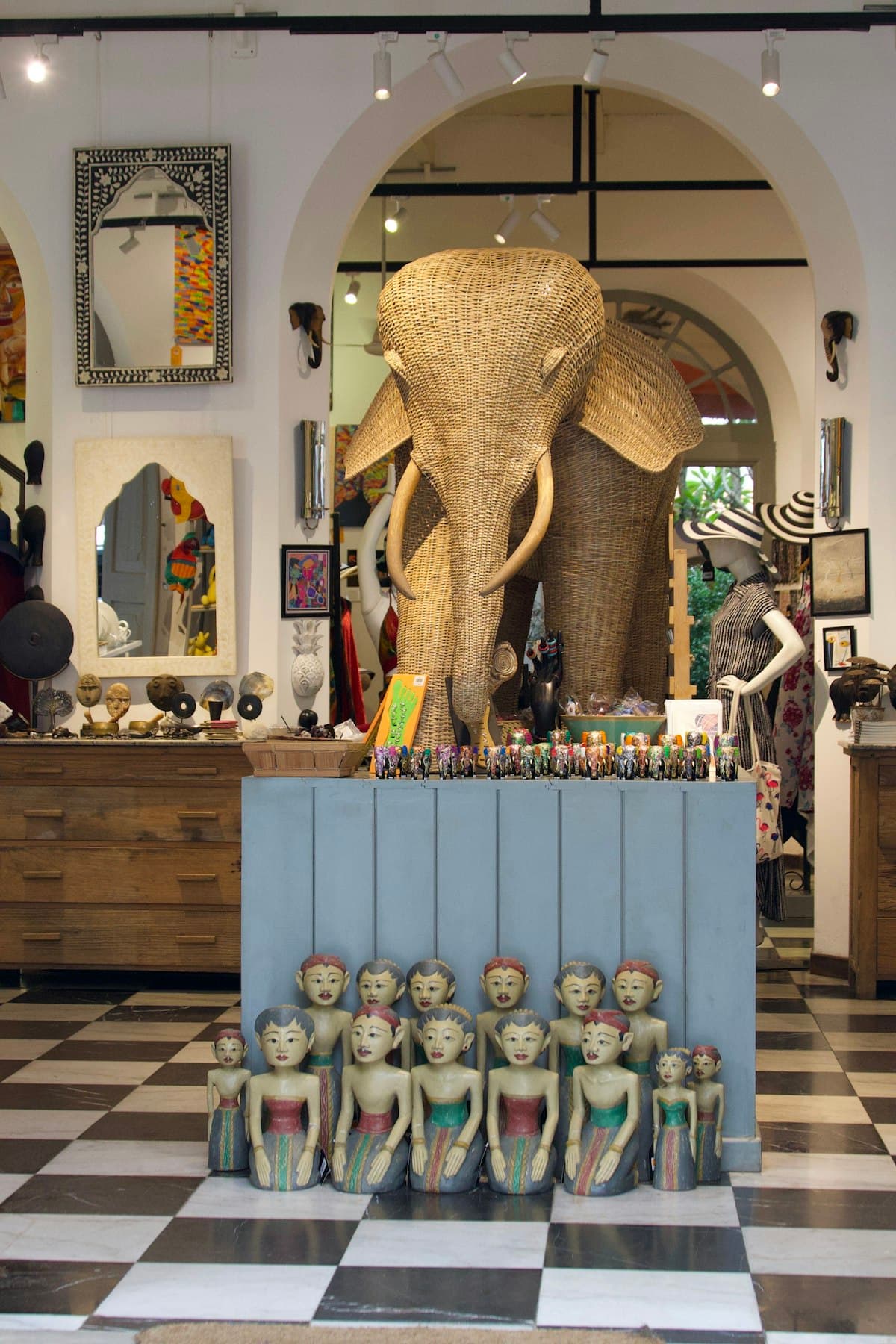 A Sri Lankan carved-elephant centrepiece and rows of carved wooden figurines in a heritage showroom