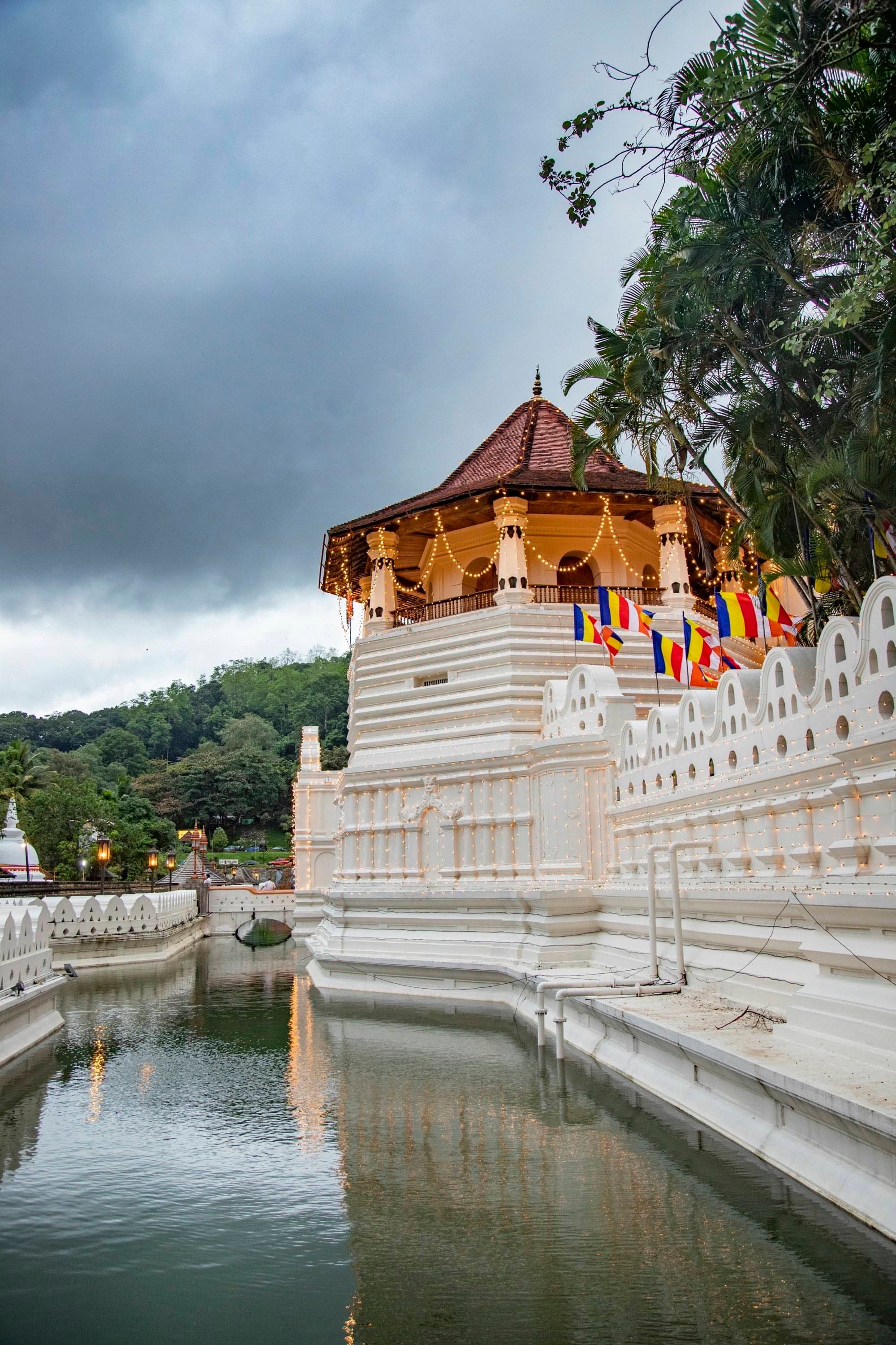 Sri Dalada Maligawa — the Temple of the Sacred Tooth Relic — mirrored across the moat in Kandy